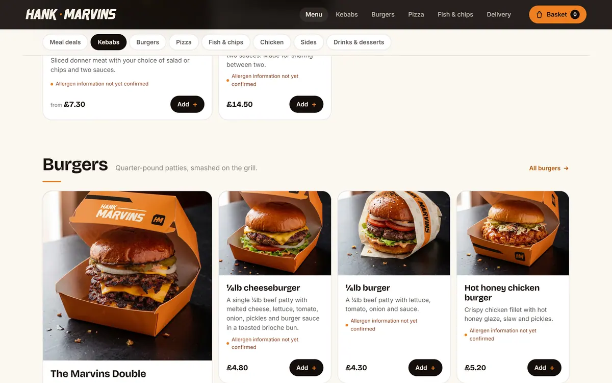 The Hank Marvins menu page on a desktop screen, showing the burgers section with photographed dishes, descriptions, allergen notes and prices